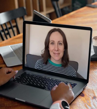 Woman using laptop to access online therapy with Dr. Katy Hill